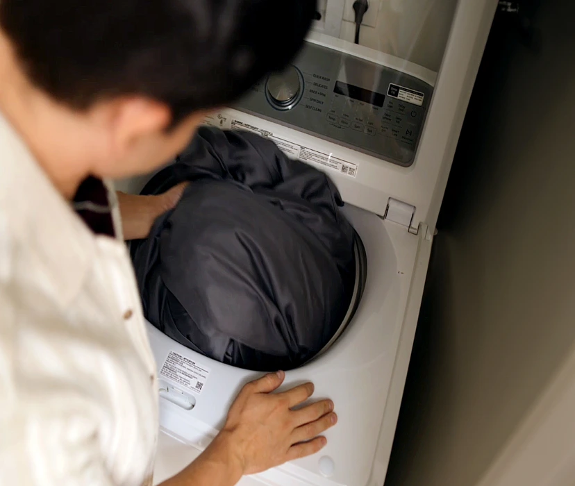 Man putting sheets in washing machine